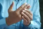 une personne ayant des douleurs articulaires aux doigts