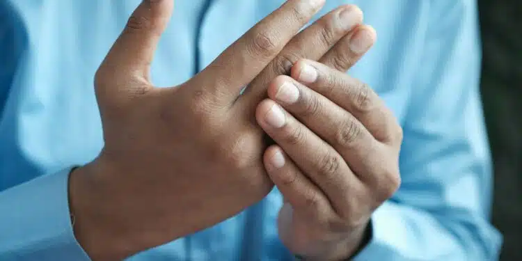 une personne ayant des douleurs articulaires aux doigts